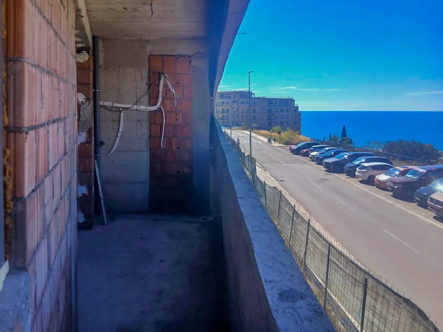 Neizgrađen balkon sa pogledom na ulicu i more.