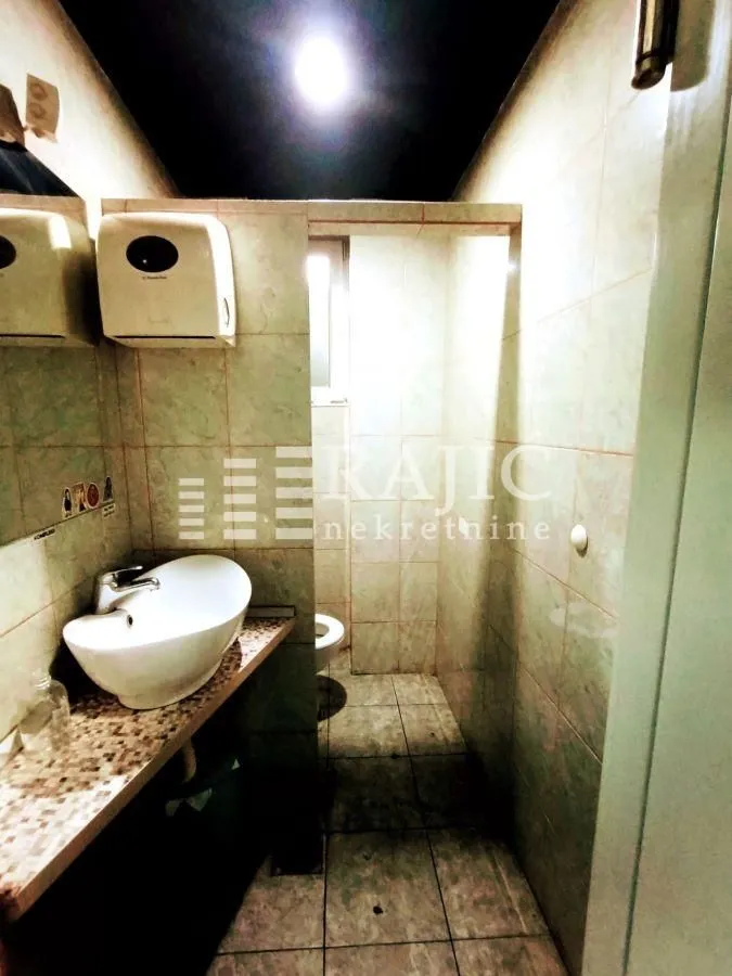 Small bathroom with a sink and tiled walls.
