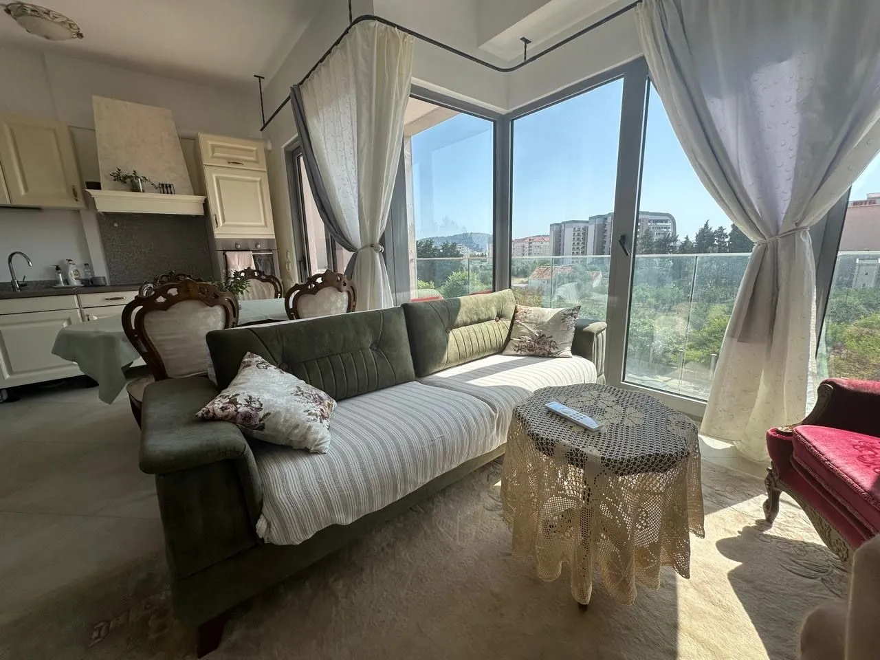 Living room with a sofa and large windows overlooking the surroundings.
