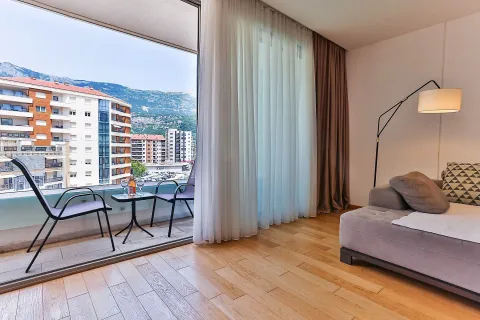 Dnevna soba sa garniturom i izlazom na terasu sa pogledom na grad i planine. - image 9