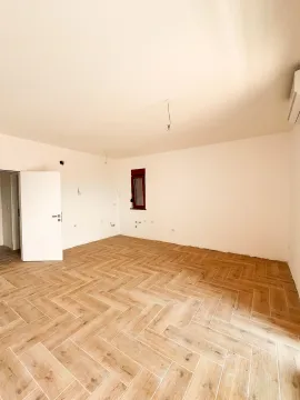 Prazna prostorija sa drvenim podom i bijelim zidovima. - image 4
