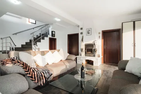 Spacious living room with a sofa set, fireplace, and stairs in the background. - image 8