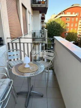 Small furnished balcony with a table and chairs. - image 19