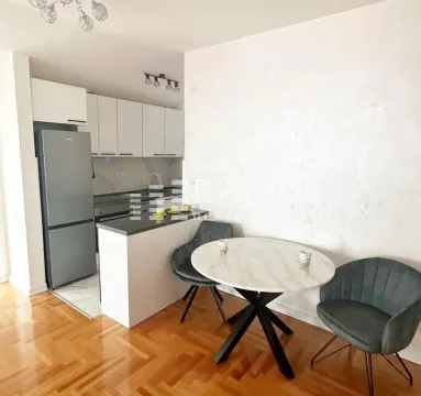 Smaller kitchen with a dining table and chairs inside the apartment. - image 3