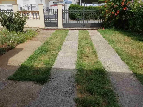 Yard with a concrete path and gate. - image 2