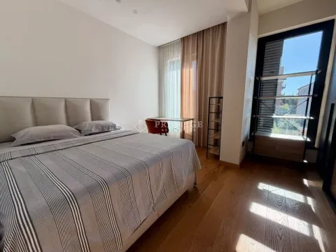 Modern bedroom with a double bed, a desk, and a large window. - image 13