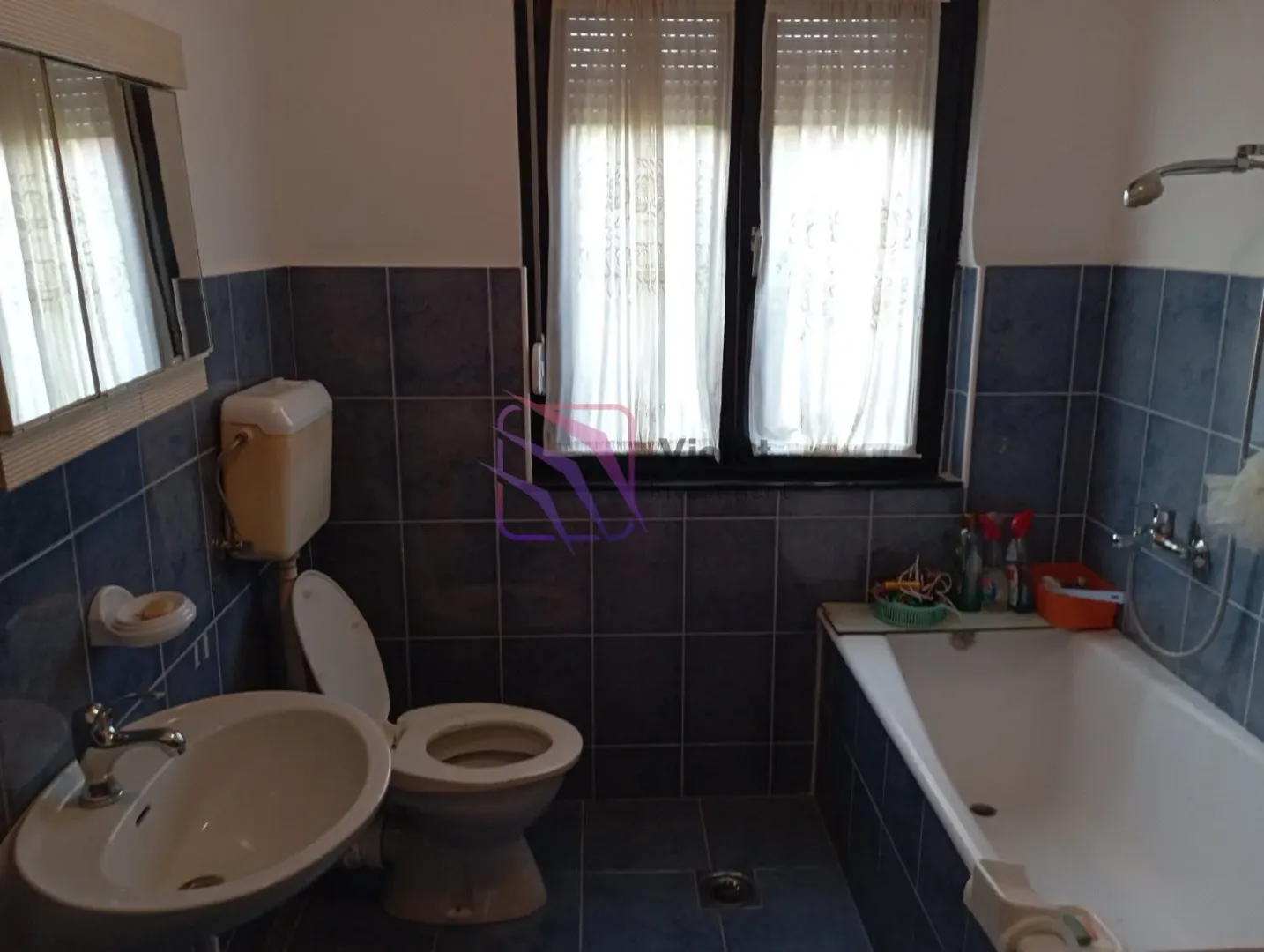 Kupatilo opremljeno tuš kabinom, umivaonikom i WC šoljom.