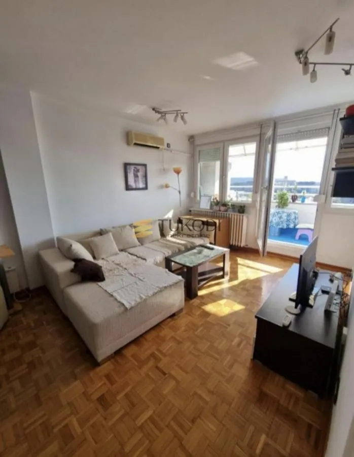 Living room with a sectional sofa, coffee table, and access to the terrace.