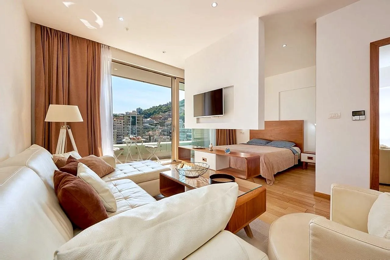 Living room connected to the bedroom with access to a balcony overlooking the city.