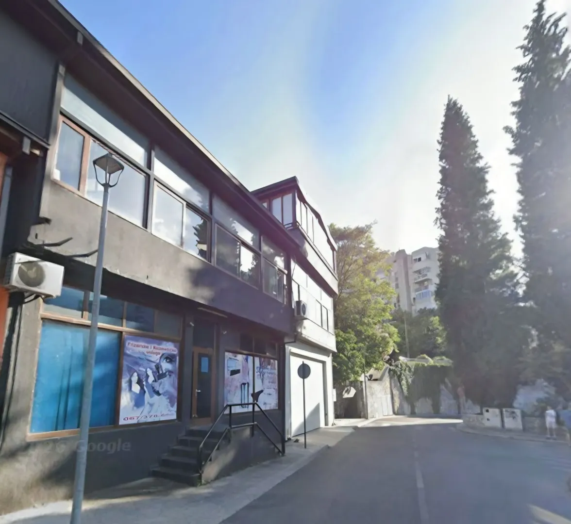 Exterior view of a commercial building with a dark facade on the street.