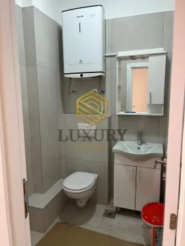 Smaller bathroom with toilet, sink, and water heater. - image 4