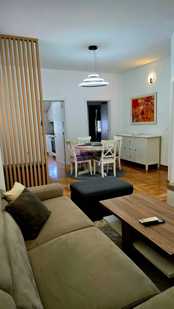 Living room with a sofa set, dining area, and a wooden partition screen.