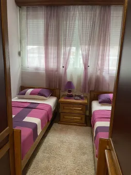 Bedroom with two single beds and a nightstand. - image 23