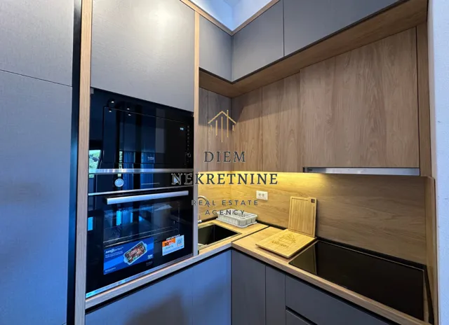 Modern kitchen with built-in appliances and wooden and grey cabinetry.