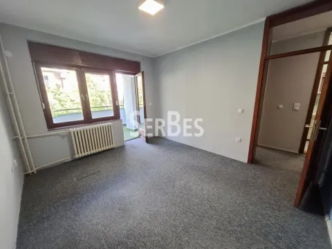 Prazna soba sa sivim zidovima, tepihom, radijatorom i izlazom na terasu. - image 10