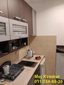 Small kitchen with cabinets and a cooktop. - image 11