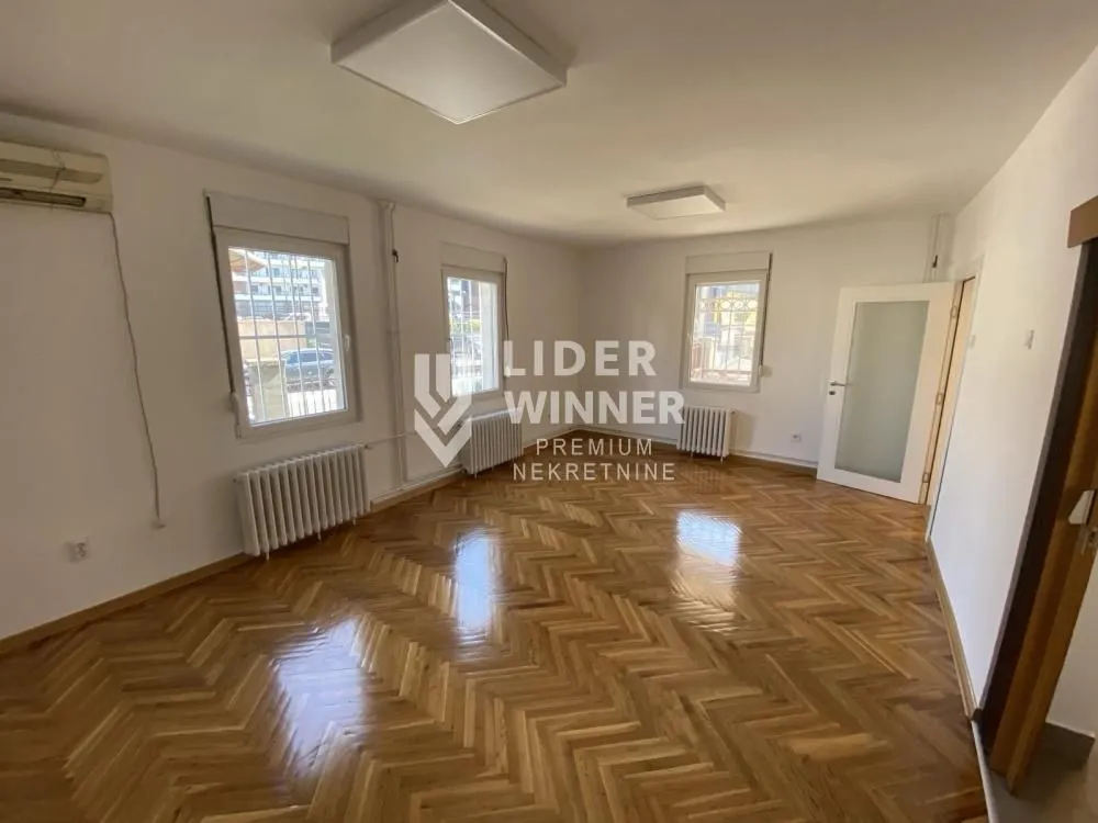 Empty room with parquet flooring and white walls.