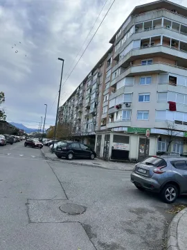 Višespratna stambena zgrada pored ulice sa parkiranim automobilima. - image 19
