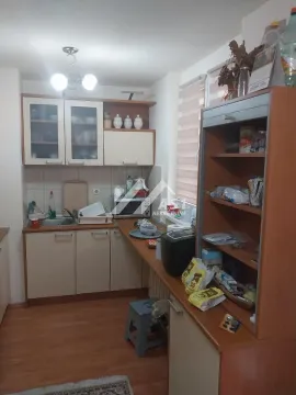Manja kuhinja sa drvenim elementima, sudoperom i radnom površinom. - image 2