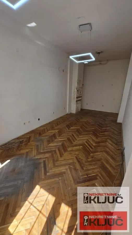 Prazna prostorija sa parketom i rasvetom.