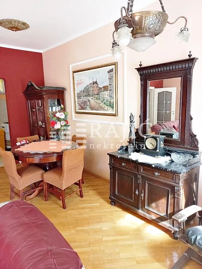 Living room with a dining table and classic wooden furniture.