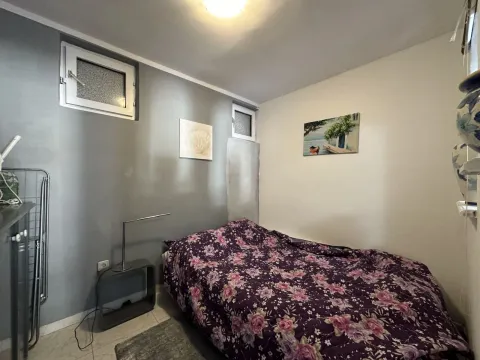 Small bedroom with a bed and decorative paintings on the wall. - image 10