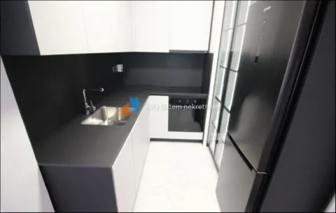 Moderna kuhinja sa crnim radnim površinama i belim elementima. - image 22