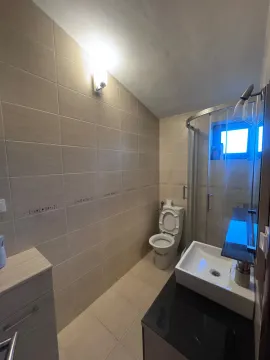 Compact bathroom with a shower cabin, washbasin, and toilet in beige tones. - image 5