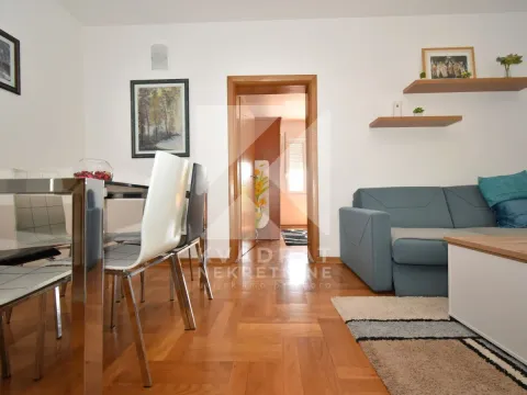 Living room with a sofa, dining table, and parquet flooring. - image 3