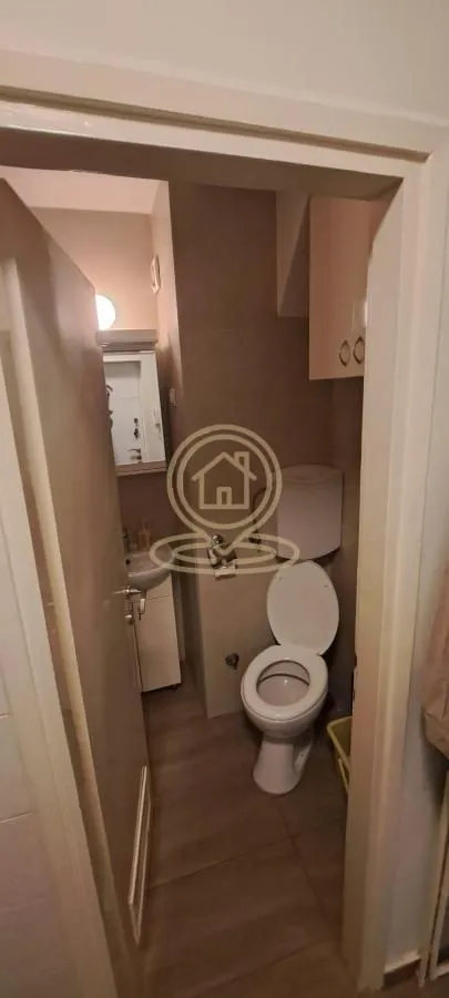 Pogled iz vrata na kupatilo sa WC šoljom i umivaonikom.