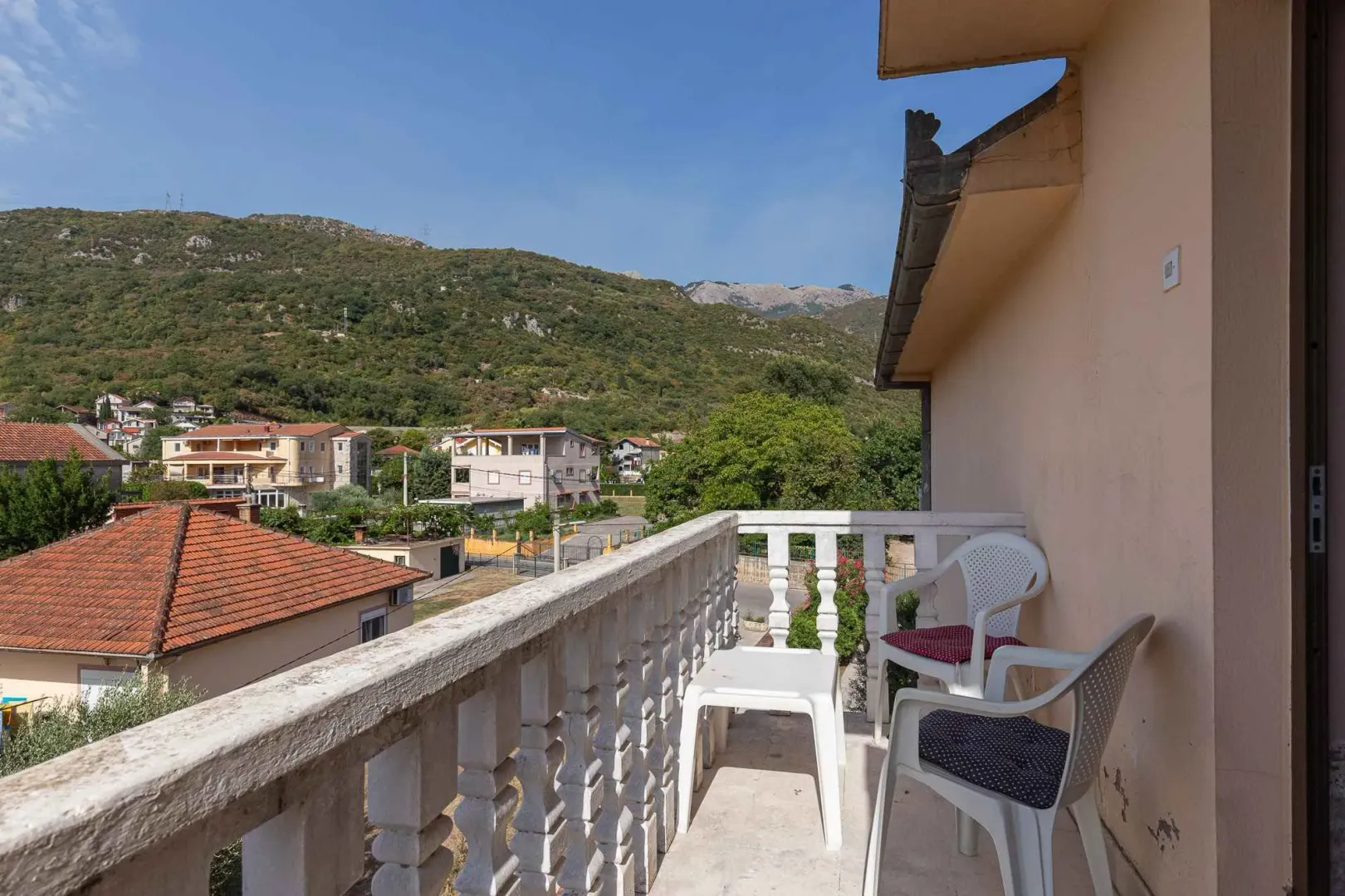 Natkriveni balkoni sa garniturom za sjedenje i pogledom na okolinu i planine.