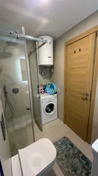 Modernly equipped bathroom with a shower cabin and washing machine. - image 7