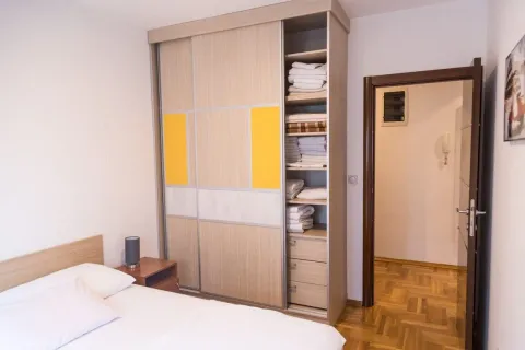 Spavaća soba sa bračnim krevetom, velikim ugradnim garderoberom i vratima koja vode u hodnik. - image 14