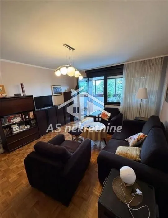 Living room with sofa set, cabinets and access to the terrace.