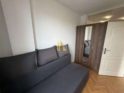 Furnished bedroom with a grey bed and a wardrobe. - image 6