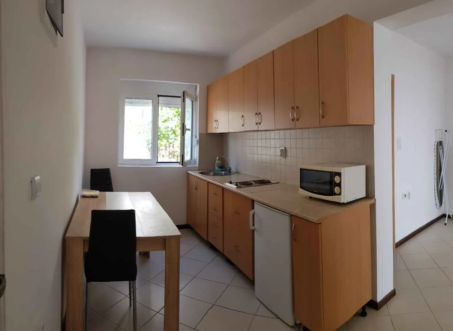 Small kitchen with wooden cabinetry and a dining table.