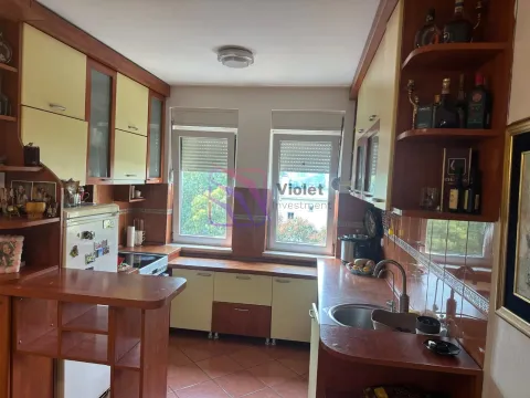 Kuhinja sa drvenim elementima, sudoperom i prozorima koji gledaju na spoljašnjost. - image 3