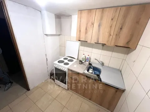 Manja kuhinja sa drvenim elementima, šporetom i sudoperom. - image 3