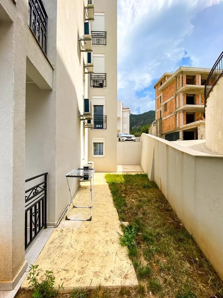 Side area of the building's courtyard with a pathway and lawn.