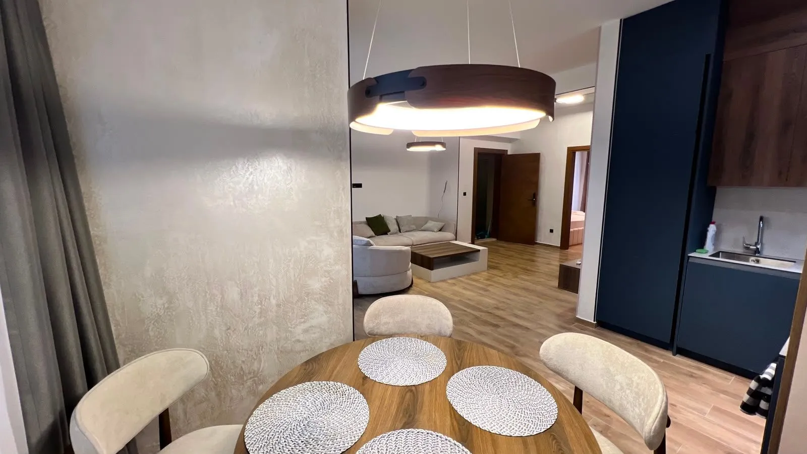 View from the dining area towards the living room and kitchen in a modern apartment.