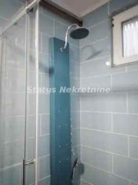 View of the shower cabin with blue tiles and a shower column in the bathroom. - image 11