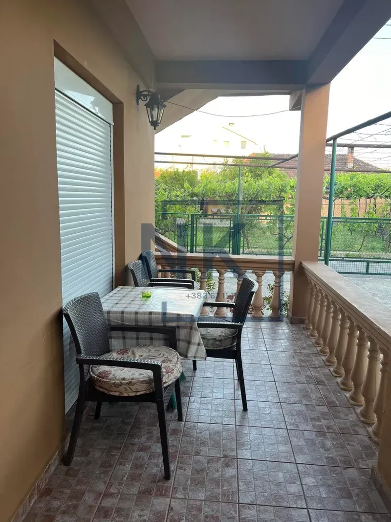 Covered terrace with outdoor seating and a view of the yard.