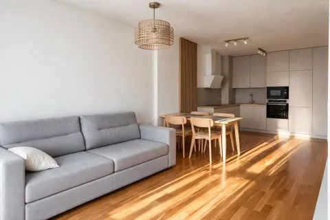 Living room with sofa, dining area, and kitchen. - image 6