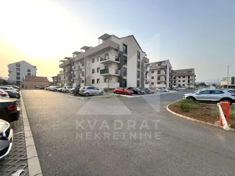 Pogled na spoljašnjost stambene zgrade sa parkingom i okolnim prostorom. - image 13