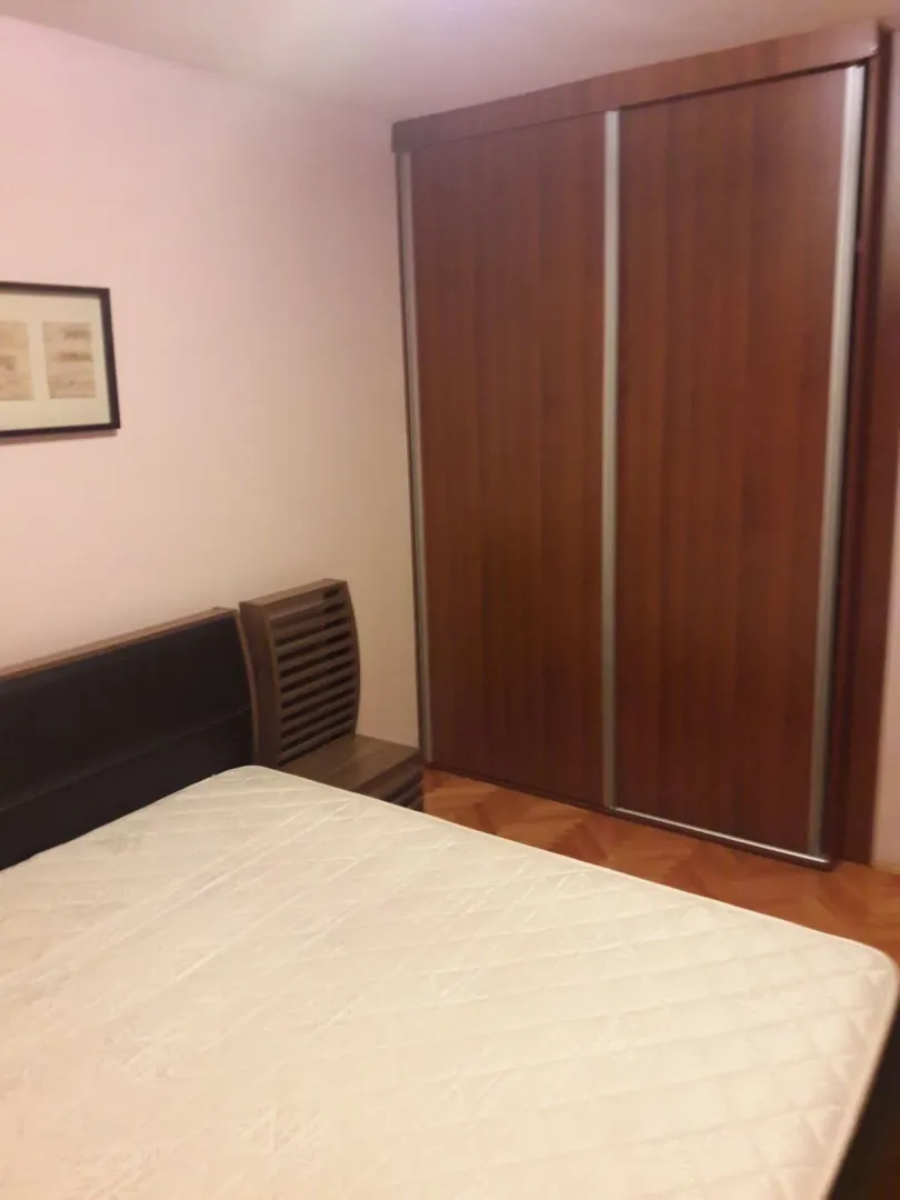 A bedroom featuring a bed and a large wooden sliding-door wardrobe.
