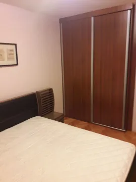 A bedroom featuring a bed and a large wooden sliding-door wardrobe. - image 9
