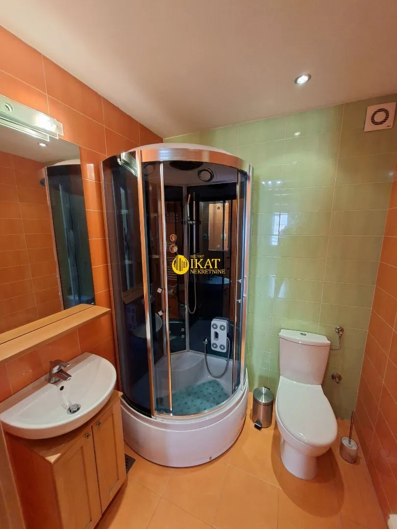 Kupatilo opremljeno tuš kabinom, umivaonikom i wc šoljom.