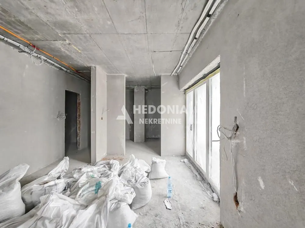 Nepotpun enterijer prostorije u izgradnji sa građevinskim materijalom.
