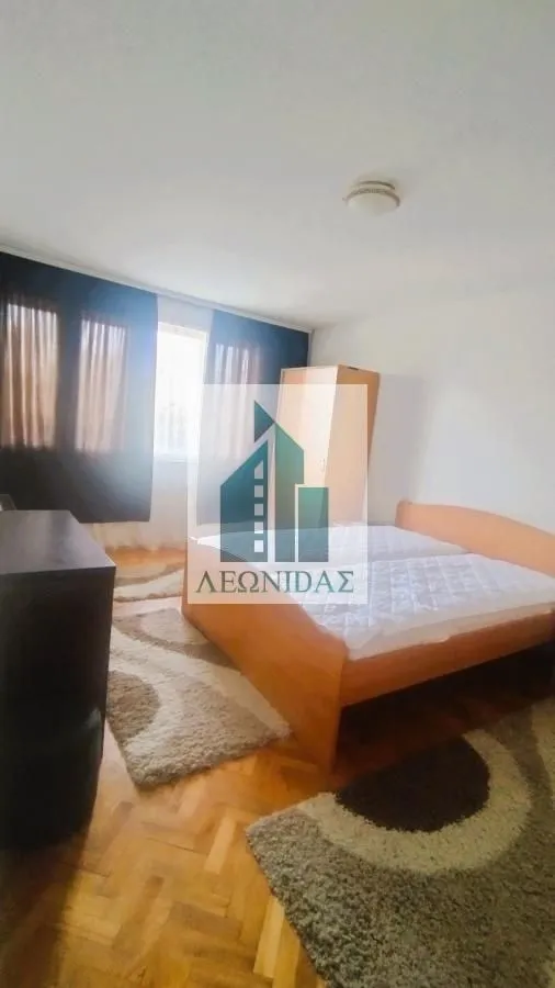 Bedroom with a double bed, wardrobe, and wooden flooring.