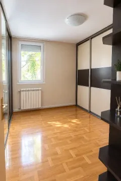 Empty room with a built-in wardrobe and parquet flooring. - image 9